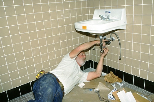 landmark associates man working on sink